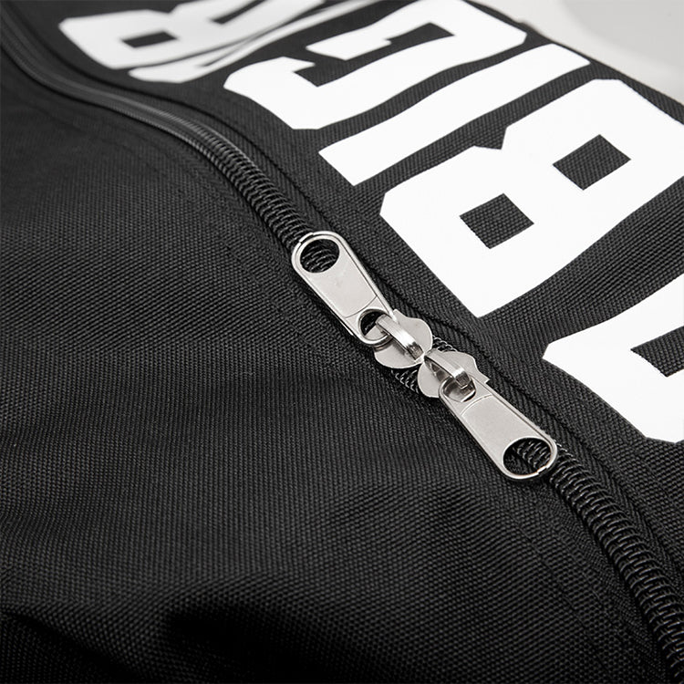 Close-up of a black jacket with a zipper and white text on a dark background